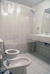 a white bathroom with a toilet and a sink at Basma Residence Hotel Apartments in Sharjah