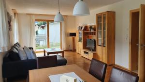- un salon avec un canapé, une table et une télévision dans l'établissement APART-PANORAMA, à Fügen