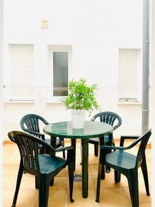 a green table and chairs with a potted plant at Precioso apartamento cerca del mar con wifi, piscina y parking in La Herradura
