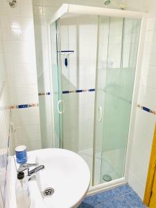 a bathroom with a sink and a glass shower at Precioso apartamento cerca del mar con wifi, piscina y parking in La Herradura