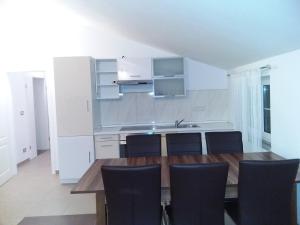 a kitchen with a wooden table and black chairs at House apartments Ariamare in Poreč