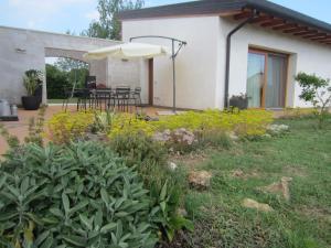 a house with a patio with an umbrella at Aganis in Casarsa della Delizia
