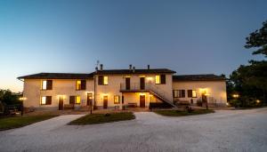 een groot huis met een oprit ervoor bij Agriturismo Podere Coldifico in Sassoferrato