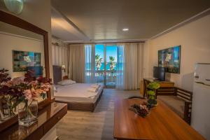 um quarto de hotel com uma cama e uma sala de estar em Theo Beach Hotel Apartments em Rethymno Town