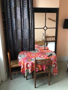 a bedroom with a table and two chairs and a mirror at Ethnique in Rochefort