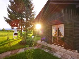 una casa con el sol brillando a su lado en MERIKOTKA - a cozy wooden cottage, sLOVEnia, en Braslovče