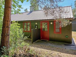 a green and red house with a red door at 6 person holiday home in Nex in Snogebæk