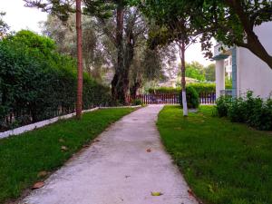 um caminho num parque com árvores e uma cerca em Harmony Garden em Parga