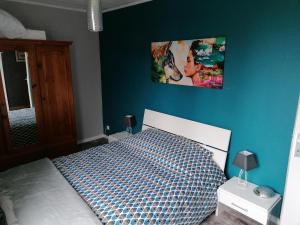 1 dormitorio con 1 cama con pared azul en La Parisiere ,gite, en Gavray