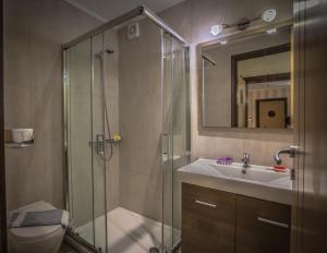 y baño con ducha y lavamanos. en Theo Beach Hotel Apartments, en Rethymno