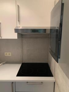 Un horno de estufa en una cocina con gabinetes blancos. en Les oyats, en Nieuwpoort 5 fotos más