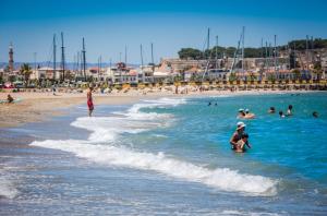 a group of people in the water at a beach at Theo Beach Hotel Apartments in Rethymno Town
