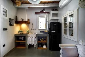 a kitchen with a black refrigerator in a room at Spitaki Serifos Studio in Rámos