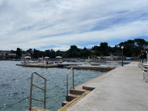 a dock with stairs and boats in the water at Apartments Simoneta in Malinska