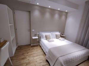 een witte slaapkamer met een groot bed met witte lakens bij Seabed superior rooms in Termoli