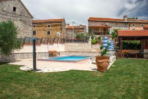 a backyard with a swimming pool and a house at Holiday Home Darko in Svetvinčenat