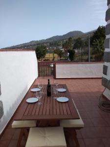 una mesa de madera con copas y una botella de vino en Casa Las Vistas, en Puntagorda