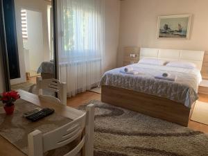 ein Schlafzimmer mit einem großen Bett und einem Tisch in der Unterkunft Apartments Knežević in Ulcinj