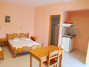 a bedroom with a bed and a table and a refrigerator at STUDIOS LEFTERIS in Nydri