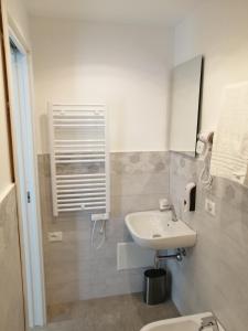 biała łazienka z umywalką i toaletą w obiekcie Bed and Breakfast My home w Pizie