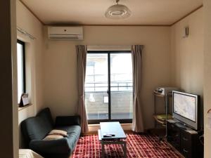 a living room with a couch and a tv at SUMIDA in Osaka