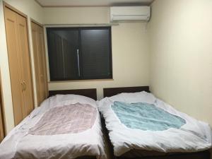 two beds in a small room with a window at SUMIDA in Osaka