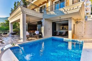 a swimming pool in front of a house at Boutique Hotel Tate By Aycon in Budva