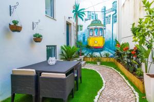 a table and chairs in a garden with a mural at Picasso Apartment in Lisbon