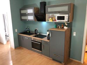 een kleine keuken met een fornuis en een magnetron bij Ferienwohnung Linnea - TOP Lage direkt in Braunlage in Braunlage