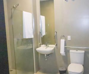 a bathroom with a sink and a toilet and a shower at Hotel Alvorada - Trindade do Sul in Trindade +18 photos
