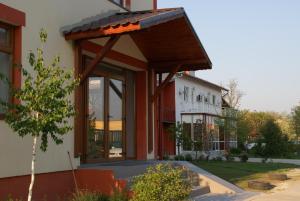 Una casa con un toldo a un lado. en Hotel Otopeni, en Otopeni