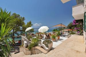 a patio with a lot of plants and umbrellas at Apartment Chiara in Tučepi