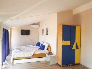 1 dormitorio con 1 cama de color azul y amarillo en Villa Amsterdam, en Ohrid