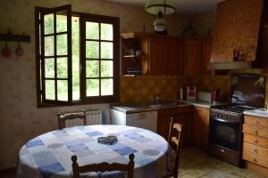 a kitchen with a table with a blue and white checkered table cloth at 'Les Comètes' B&B in La Caujonnet