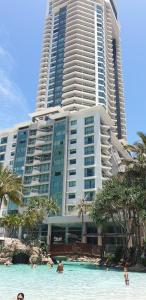 a large building with people in the water in front of it at Crown Towers Resort Private Apartments in Gold Coast