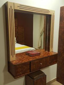 a mirror on top of a wooden dresser at رانا الخليجية - rana alkhaleejiah in Riyadh Al Khabra