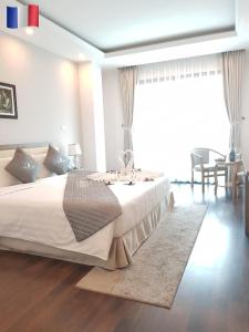 a bedroom with a large white bed with a rug at The Pilgrim Hotel in Hanoi