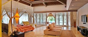 a living room with a bed and a couch at Ayurvedagram Bali in Ubud