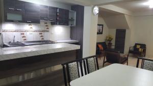 cocina con encimera, mesa y sillas en Aparts Downtown Arequipa, en Arequipa