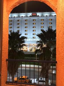 een uitzicht op een hotel met auto's voor het hotel bij Tu DEPA en el Paraíso Cancún 2 in Cancun