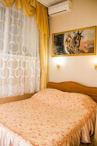 um quarto com uma cama e um quadro na parede em Inn Mega em Ussurijsk