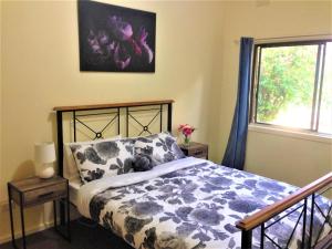 een slaapkamer met een bed en een raam bij Wombat Cottage Albury in Albury