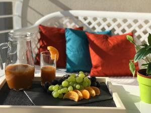 een dienblad met druiven en sinaasappelen op een tafel bij Ocean Pearl Apartment no4 in St Paul's Bay