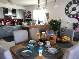 a kitchen with a table with a bowl of fruit on it at Chambre d hôtes Le Petit Bonheur in Colombier