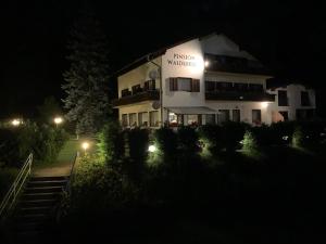 a building with a sign on it at night at Pension & Apartments Waldkrieber in Presseggersee
