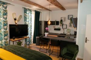 a living room with a kitchen and a desk with a television at studio coeur de ville neuf et design tt equipé parking gratuit in Sanary-sur-Mer
