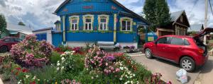 
a red car parked in front of a house at Gostevoy Dom Zakharovykh in Suzdal
