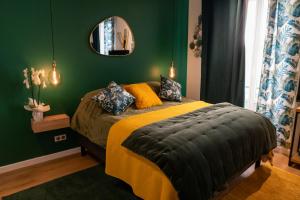 - une chambre verte avec un lit et un miroir dans l'établissement studio coeur de ville neuf et design tt equipé parking gratuit, à Sanary-sur-Mer