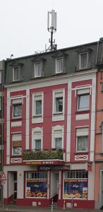 クレーフェルトにあるCentral Apartment Krefeldの看板が付いた白赤の建物