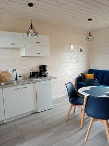 a kitchen and dining room with a table and chairs at Domki na górce in Kołczewo